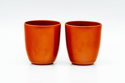 The two matching red shudei yunomi teacups shown upright side by side.