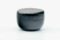 Black-lacquer floral matcha tea caddy, lid on, front view of the glossy black body