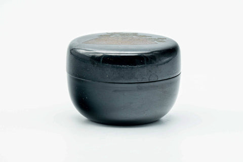 Black-lacquer floral matcha tea caddy, lid on, front view of the glossy black body