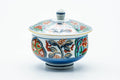 The lidded cup from another angle, blue ground with colorful floral decoration.