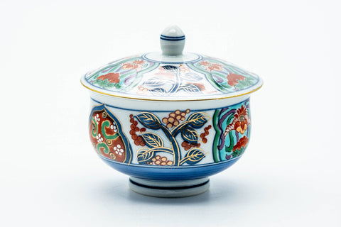 The lidded cup from another angle, blue ground with colorful floral decoration.