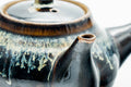 Close-up of the spout and the silvery drip-glaze streaks.