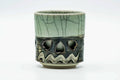 Double-walled Obori Soma-yaki teacup with a blue-green crackle glaze and a relief horse motif near the base, front view.