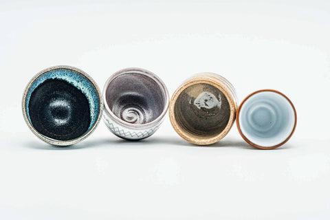 Overhead view of the four guinomi teacups revealing their varied glazed interiors.