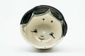 Overhead view into the cup, showing the painted face design inside the bowl.
