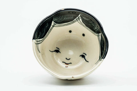 Overhead view into the cup, showing the painted face design inside the bowl.