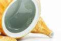 Close-up of the teapot interior showing the ceramic strainer at the base of the spout