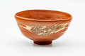 Orange-red Tokoname-yaki nerikomi matcha chawan with gold-leaf decoration, three-quarter view