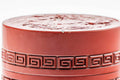 Top-down view of the lid showing the village relief and geometric border pattern