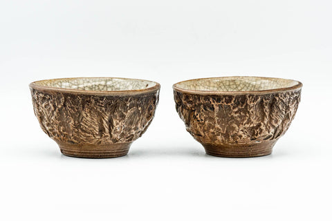 Pair of carved guinomi with green celadon interior glaze shown side by side