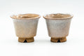 Pair of beige weathered Hagi-yaki guinomi side by side, front view, crackled cream glaze over toasted feet