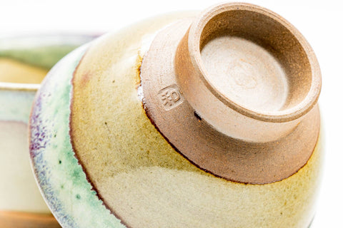 Close-up of an inverted cup showing the unglazed reddish-brown clay foot and base.