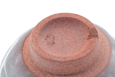 Angled underside showing the exposed clay foot and a maker's mark.