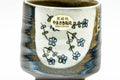 Close-up of one white cup featuring the painted floral motif and calligraphic characters.