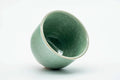 Teacup tilted to show the glazed interior and rim.