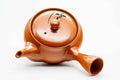 Overhead view of the red kyusu, lid on, showing the handle and spout.