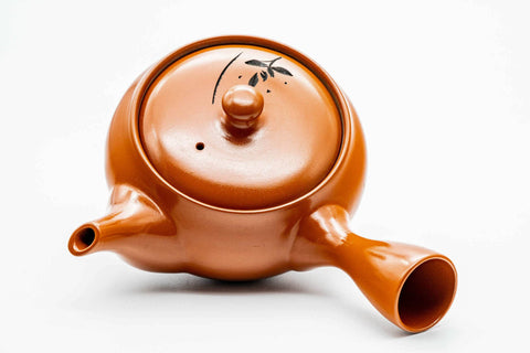 Overhead view of the red kyusu, lid on, showing the handle and spout.