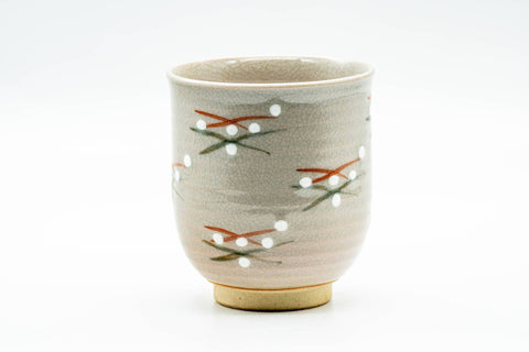 Front view of the cup showing the cream glaze and the delicate hand-painted sprig pattern.