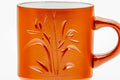 Close-up of the engraved bamboo design on the red clay body, handle visible.