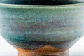 Close side view of the chawan emphasising the streaked turquoise-to-brown glaze.