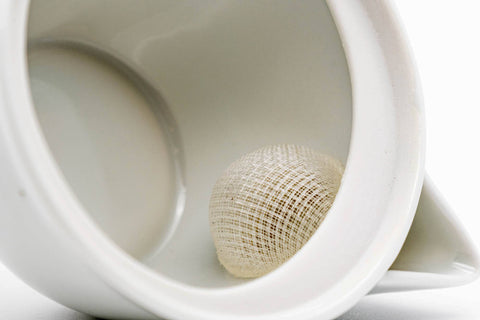 Close-up inside the white houhin showing the built-in mesh strainer.
