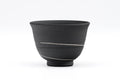 Black ceramic teacup with a white stripe on a white background