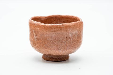 Front view of the rustic raku chawan showing the soft pink-orange surface.
