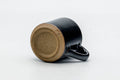 Tezumi — Japanese Teacup - Black Beige Drip-Glazed Ushirode Yunomi - 100ml — tipped to show the interior
