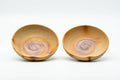 The two matching saucers shown from above, with hidasuki scorch marks in the wells.
