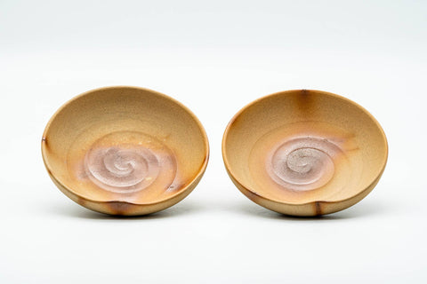 The two matching saucers shown from above, with hidasuki scorch marks in the wells.