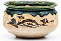 Three-quarter view showing the green Oribe glaze dripping over the rim