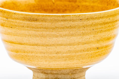 Front view of the spiralling Ki-Seto chawan, with a kintsugi repair visible along the lip.