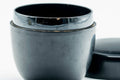 Weathered black-lacquer matcha tea caddy, lid removed, body upright showing the black-lacquered interior rim with the lid lying flat