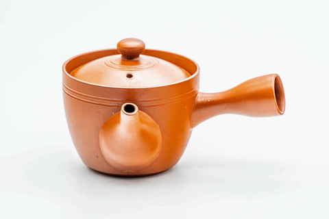 Three-quarter view of the small red kyusu with the lid on.