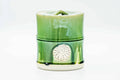 Front view of the green bamboo-form mizusashi showing molded nodes and a shell-like relief.