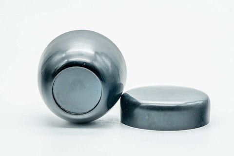 Weathered black-lacquer matcha tea caddy with the lid detached and lying flat beside the upright body
