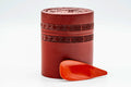 Side view of the canister body showing the engraved geometric band in red lacquer