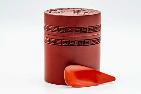 Side view of the canister body showing the engraved geometric band in red lacquer