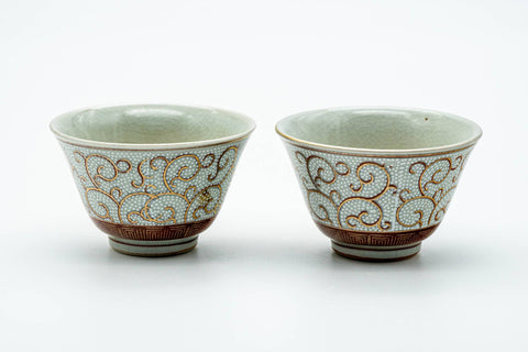 The paired cups side by side, showing the scrolling decoration.
