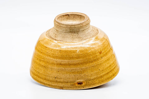 The Ki-Seto chawan inverted to reveal its tall trimmed foot and the crazed yellow glaze over the base.
