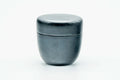 Weathered black-lacquer matcha tea caddy, lid on, front view of the smooth domed body