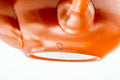 Close-up of the lower body and base resting on a white surface, highlighting the smooth red shudei clay.