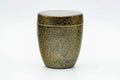 Front view of the closed gold-speckled canister.