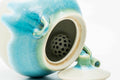 Overhead closeup looking into the Agano-yaki teapot's mouth, showing the perforated ceramic strainer and turquoise glaze