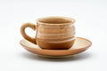 Beige drip-glazed Hagi-yaki teacup with a side handle resting on a matching coaster, front view.