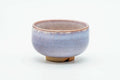 Side view of the teacup, showing the purple-and-white drip glaze.
