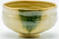 Side view of the Akahada chawan showing the green drip and cream glaze