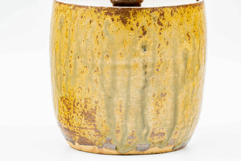 Front view emphasising the vertical brown drip glaze on the body of the jar.