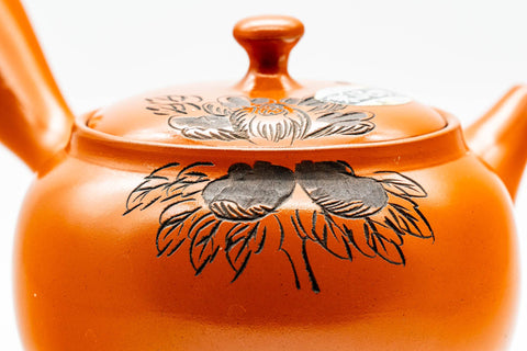Close-up of the engraved floral decoration on the red shudei surface.