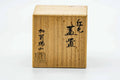 The closed wooden presentation box with calligraphy markings.